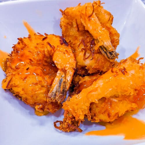 three coconut shrimp topped with spicy apricot sauce