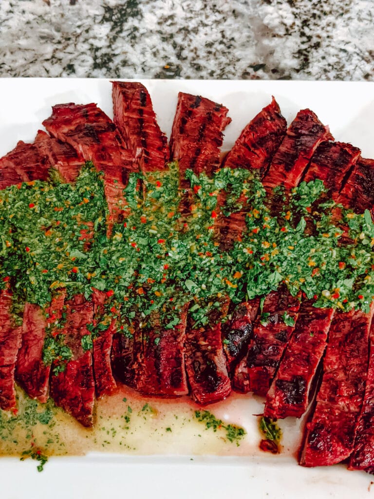 Flank steak fanned with chimichurri sauce on top.